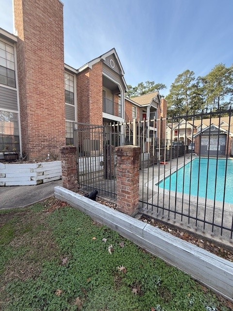 2402 Sycamore Avenue, Unit E3 Huntsville, TX 77340 - Photo 2 of 38 a view of a house with a small yard and wooden fence