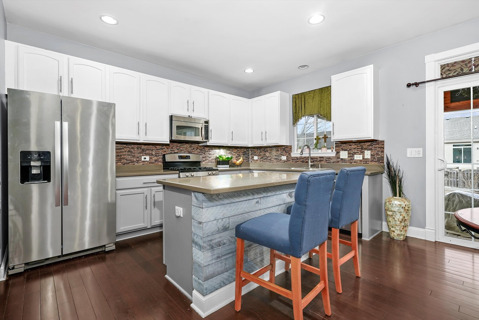 902 Farmstead Lane Shorewood, IL 60404 - Photo 14 of 35 a kitchen with stainless steel appliances granite countertop a stove a refrigerator a sink a stove and white cabinets with wooden floor