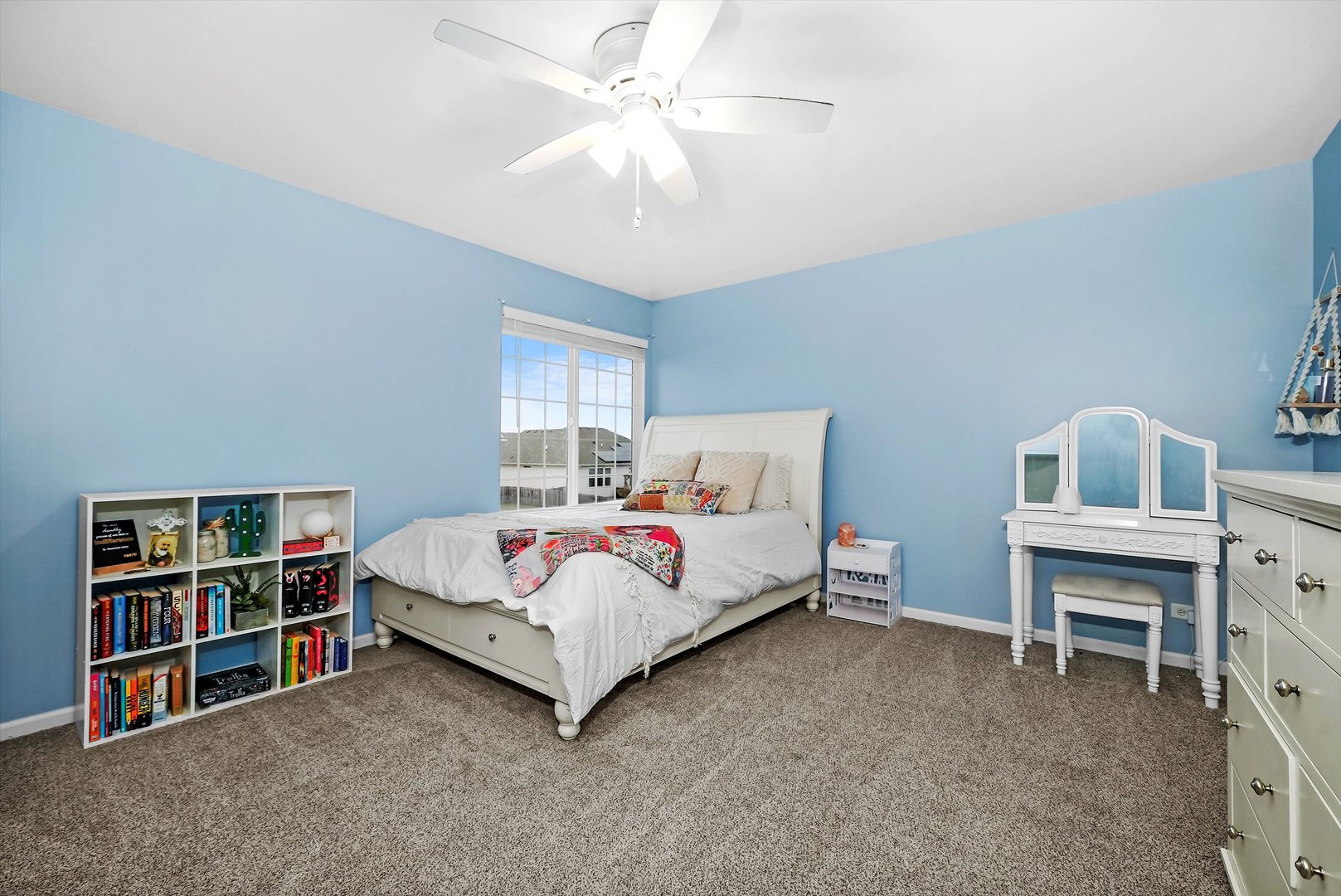 902 Farmstead Lane Shorewood, IL 60404 - Photo 22 of 35 a bedroom with a bed books dresser and a chandelier
