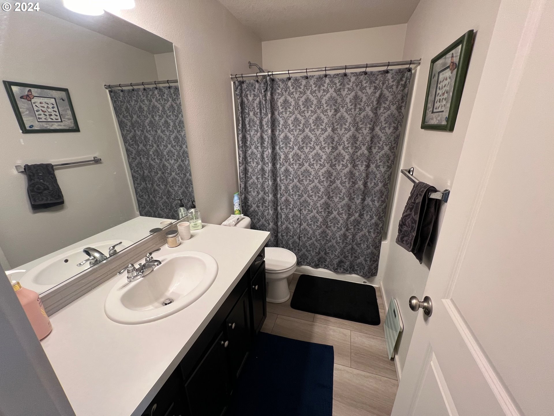 2044 South Chukar Drive Ridgefield, WA 98642 - Photo 11 of 16 a bathroom with a sink a toilet a shower curtain and a mirror