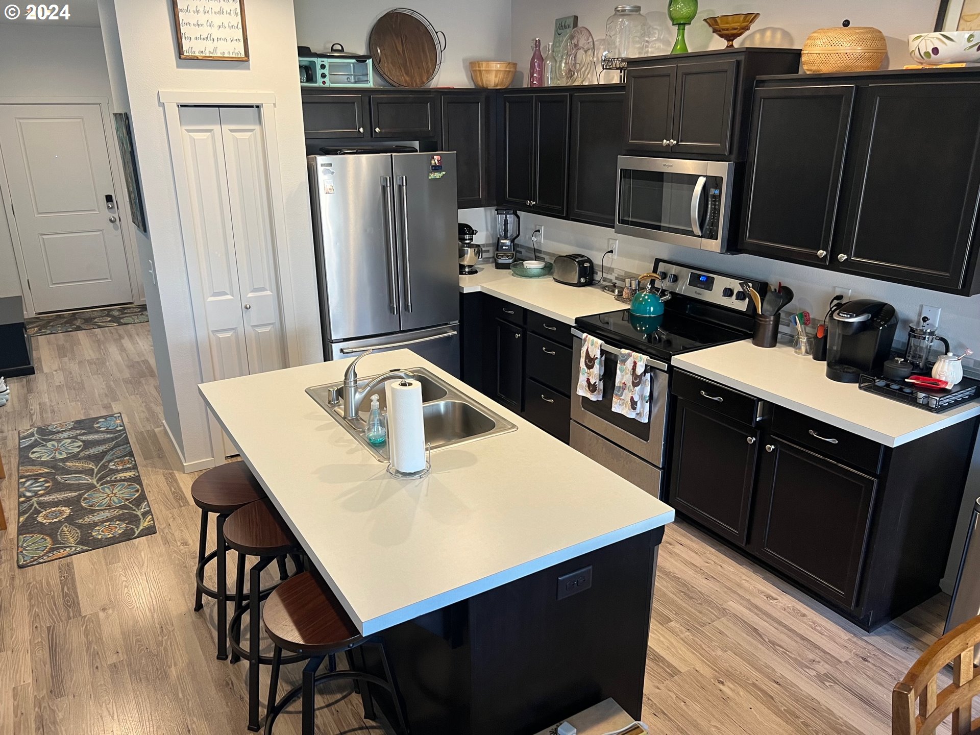 2044 South Chukar Drive Ridgefield, WA 98642 - Photo 4 of 16 a kitchen with stainless steel appliances kitchen island granite countertop a refrigerator a stove and a microwave oven with wooden floor