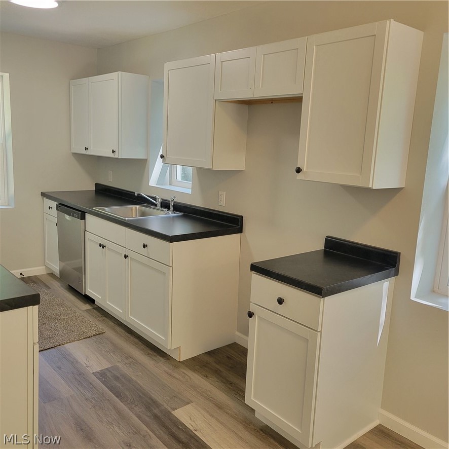 1500 Warner Road Southeast Canton, OH 44707 - Photo 3 of 21 Kitchen with sink, light hardwood / wood-style flooring, dishwashing machine, and white cabinets