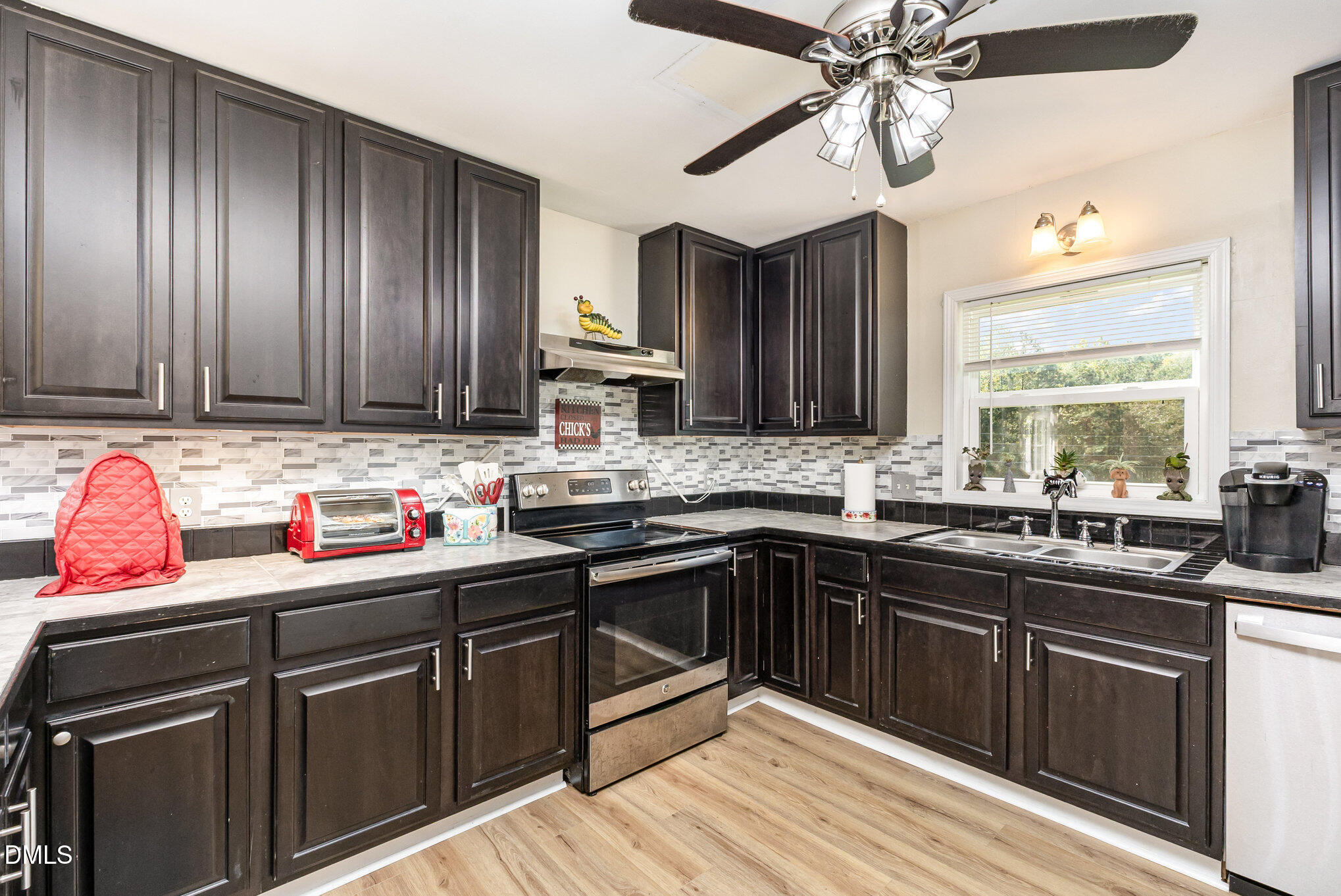 365 Landmark Road Willow Spring, NC 27592 - Photo 12 of 27 a kitchen with a sink dishwasher a stove and a microwave oven with cabinets