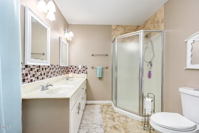 a view of a hallway with wooden floor and a bathroom