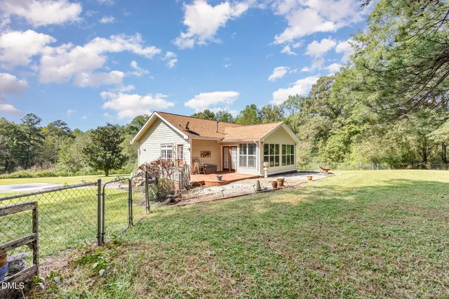 a view of a house with a big yard and sitting area