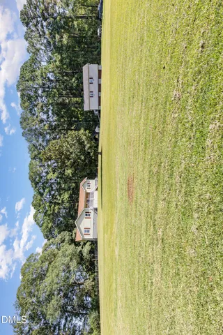 a view of a house with pool and chairs next to trees