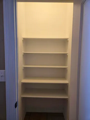 a view of walk in closet with empty racks