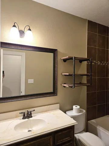 a bathroom with a sink a toilet and a mirror