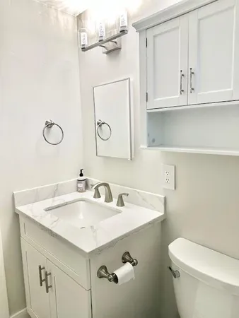 a bathroom with a sink toilet and mirror