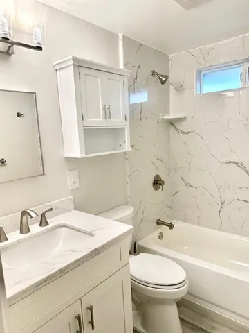 a bathroom with a sink toilet vanity and shower