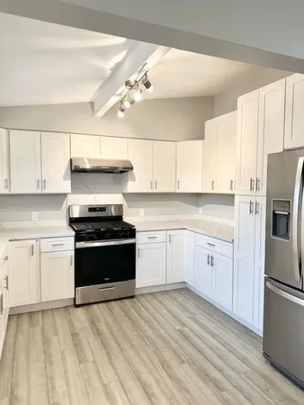 a kitchen with a refrigerator stove top oven and cabinets