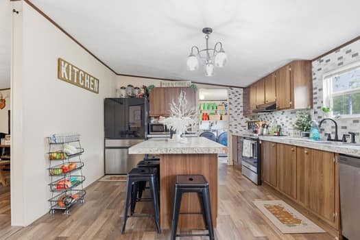 12947 Ralston Drive Conroe, TX 77306 - Photo 13 of 24 a kitchen with kitchen island stainless steel appliances a dining table chairs sink and cabinets