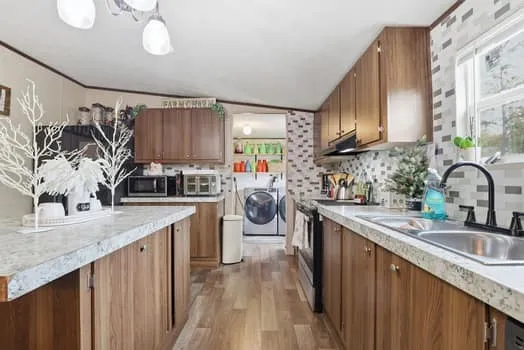a kitchen with stainless steel appliances granite countertop a sink stove and cabinets