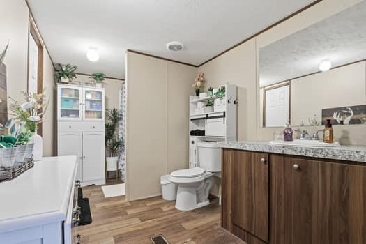 12947 Ralston Drive Conroe, TX 77306 - Photo 17 of 24 a bathroom with a granite countertop sink a toilet a mirror and shower