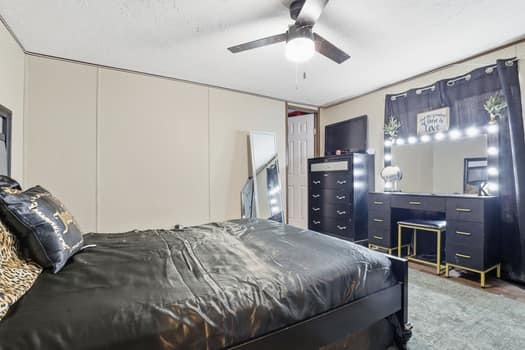 12947 Ralston Drive Conroe, TX 77306 - Photo 21 of 24 a bedroom with a large bed and a chandelier