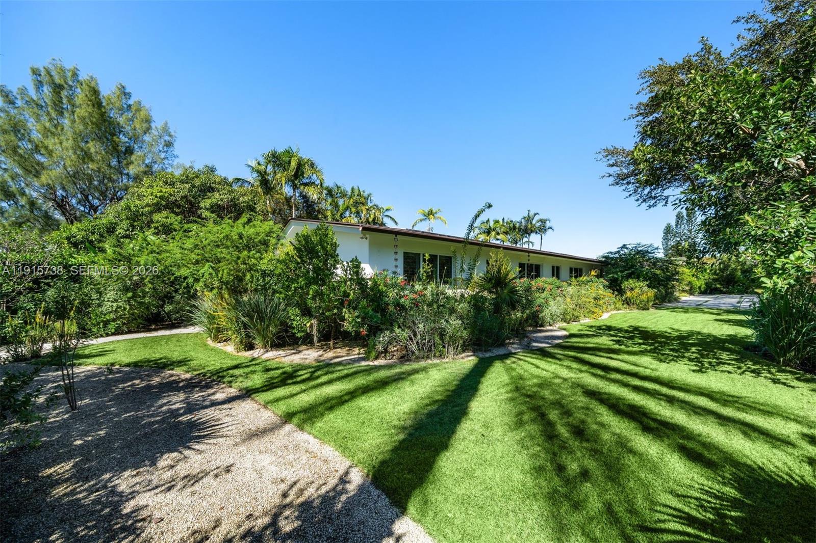 12050 Moss Ranch Road Pinecrest, FL 33156 - Photo 27 of 33 a view of a backyard with plants and a garden