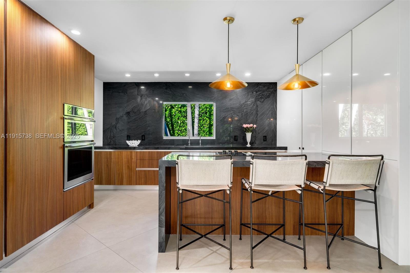 12050 Moss Ranch Road Pinecrest, FL 33156 - Photo 7 of 27 a kitchen with a sink a counter and chairs