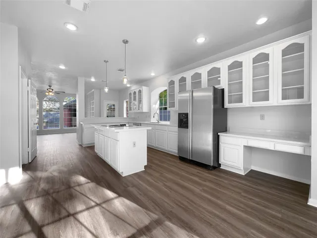 a large kitchen with stainless steel appliances kitchen island a large counter top and a wooden floors