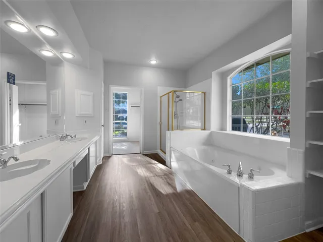 a large white kitchen with a large window a sink and stainless steel appliances