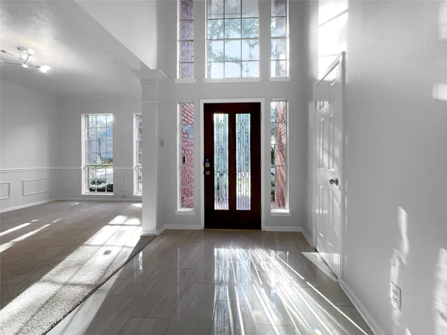 a view of a hallway with wooden floor and windows