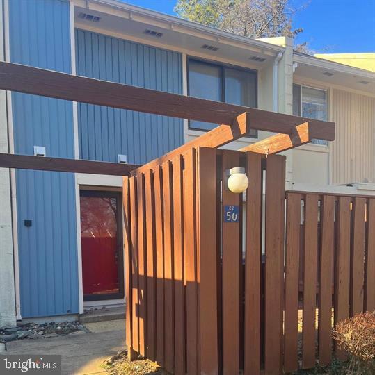 a view of a house with backyard and wooden fence
