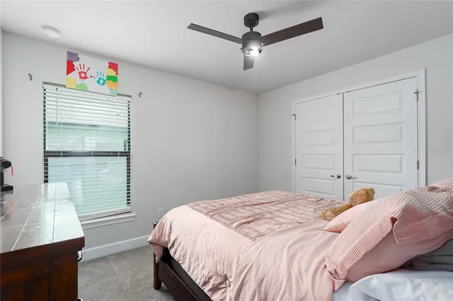a bedroom with a bed a dresser and a window