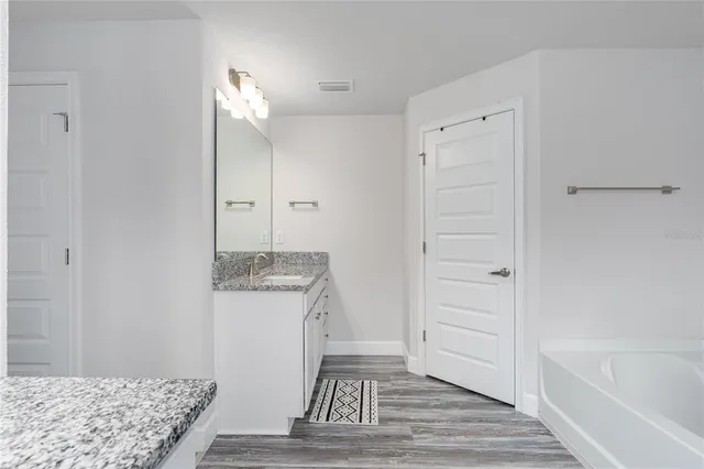 a bathroom with a tub shower and a sink