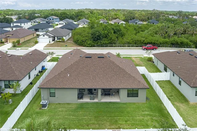 an aerial view of a house with a garden and lake view