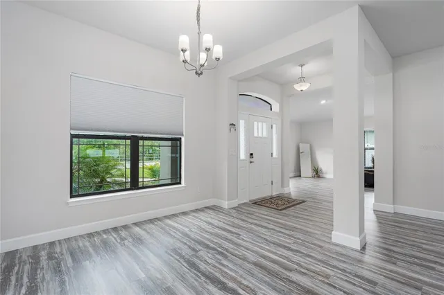 a view of a livingroom with a chandelier wooden floor and a chandelier