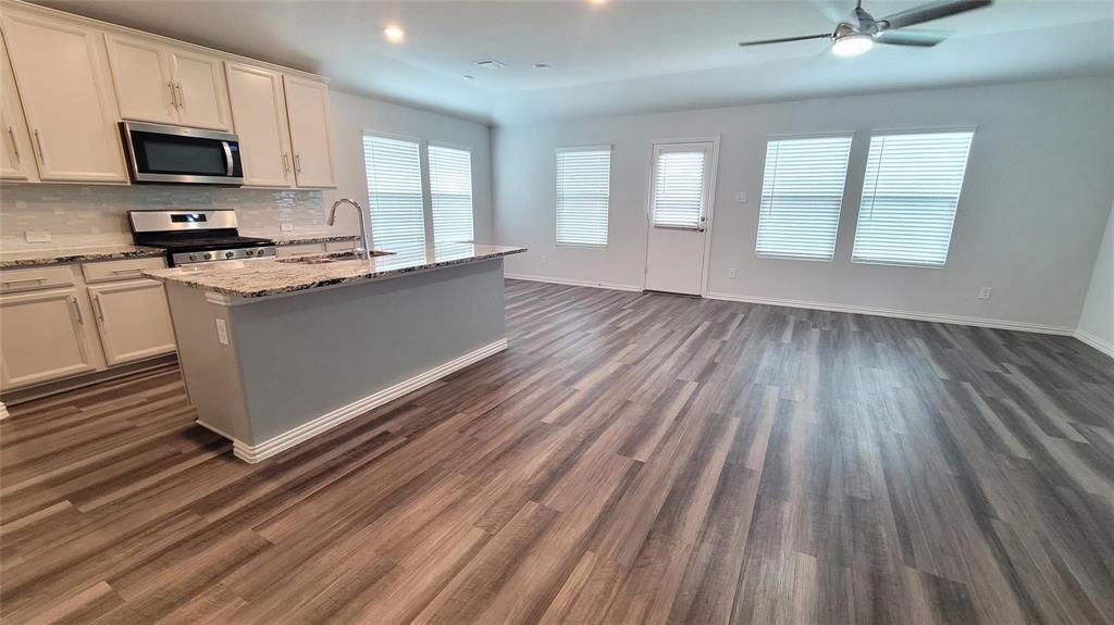 263 Sunshine Lane Lavon, TX 75166 - Photo 26 of 27 a kitchen with granite countertop a stove top oven a sink and dishwasher a oven with wooden floors