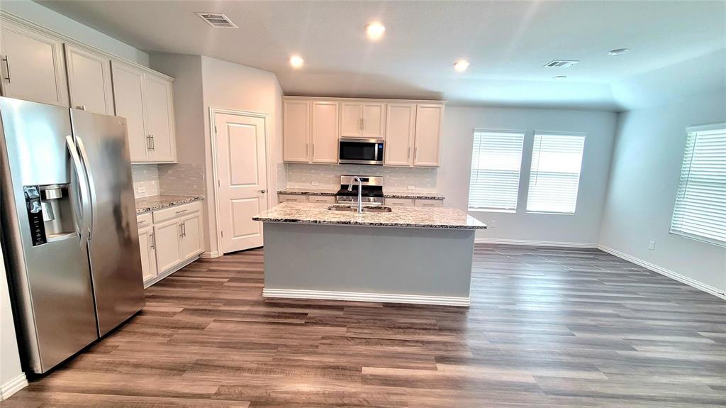 263 Sunshine Lane Lavon, TX 75166 - Photo 12 of 27 a kitchen with stainless steel appliances kitchen island granite countertop a stove a sink dishwasher and a refrigerator