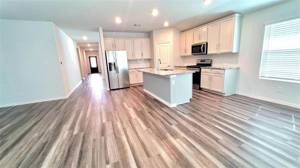 263 Sunshine Lane Lavon, TX 75166 - Photo 16 of 27 a kitchen with white cabinets a sink a window and stainless steel appliances