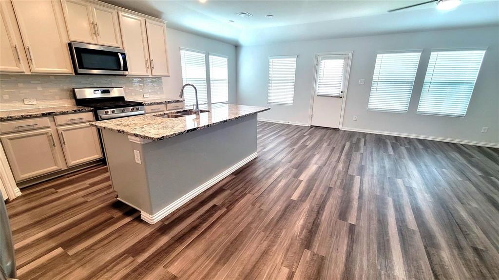 263 Sunshine Lane Lavon, TX 75166 - Photo 21 of 27 a kitchen with wooden floors and white appliances