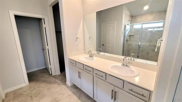 a bathroom with a double vanity sink and mirror