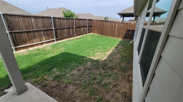 a view of a backyard with wooden fence
