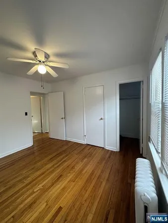 a view of a livingroom with a ceiling fan window and wooden floor