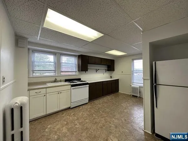 a kitchen with stainless steel appliances a refrigerator sink and white cabinets