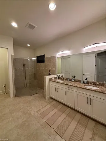 a large bathroom with a large mirror vanity and shower