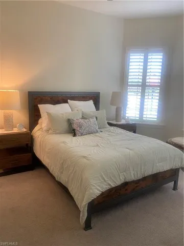 a large bed sitting in a bedroom next to a window