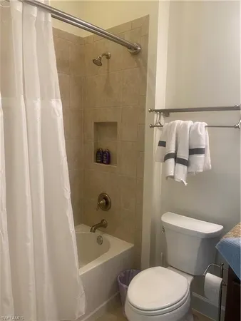 a white toilet and shower curtain