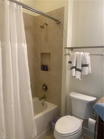 a white toilet and shower curtain