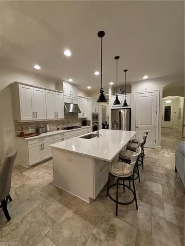 a kitchen with stainless steel appliances kitchen island granite countertop a sink and cabinets