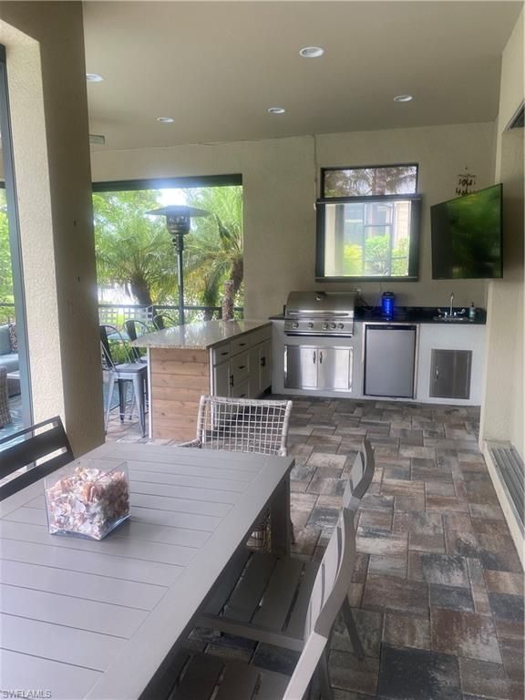 9571 Mussorie Court Naples, FL 34114 - Photo 22 of 26 a living room with stainless steel appliances furniture a flat screen tv and floor to ceiling window