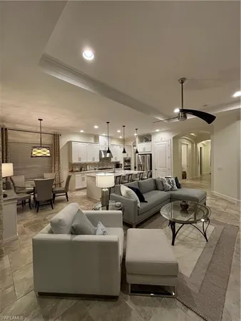 a living room with couches and kitchen view