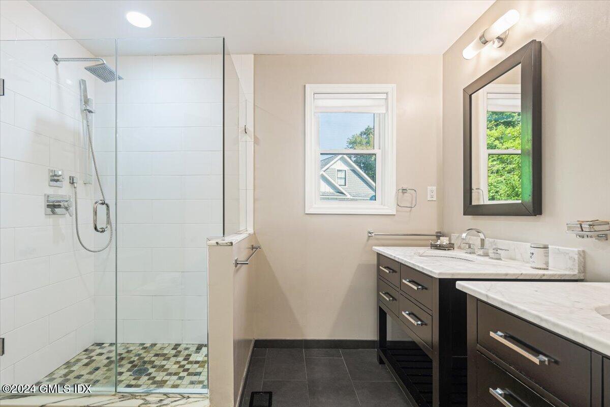 70 Gregory Road Cos Cob, CT 06807 - Photo 15 of 39 a bathroom with a shower sink and mirror