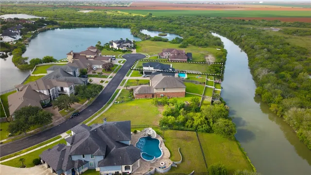 an aerial view of a house with a garden and lake view