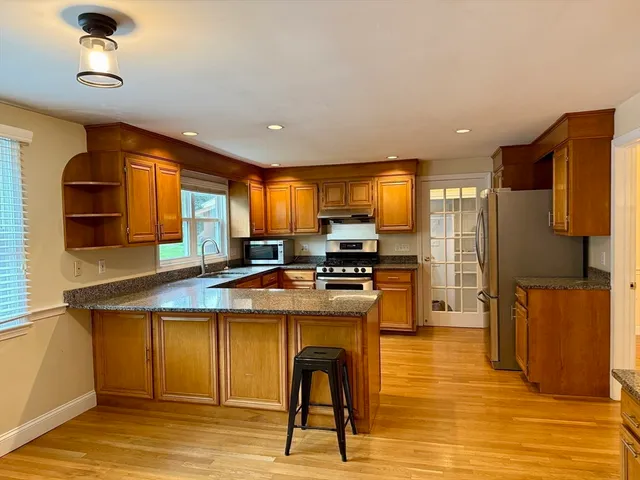 a kitchen with stainless steel appliances granite countertop a refrigerator a stove and a sink