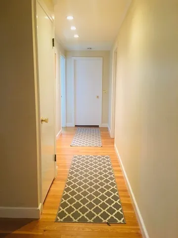 a living room with wooden floor and a fireplace