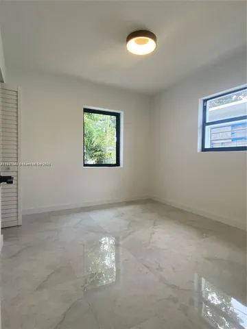 an empty room with windows and painted walls