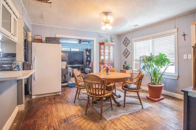 a dining room with furniture potted plants and wooden floor